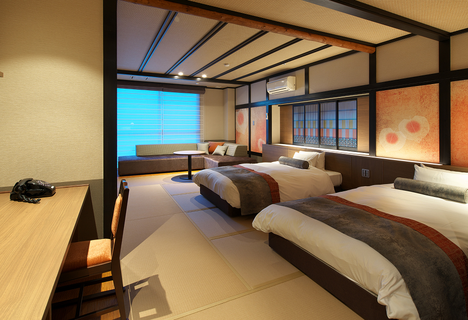 畳敷きの部屋に、ふかふかの布団が二つ並んでいる。奥にはソファとテーブルが置かれたくつろぎスペース。